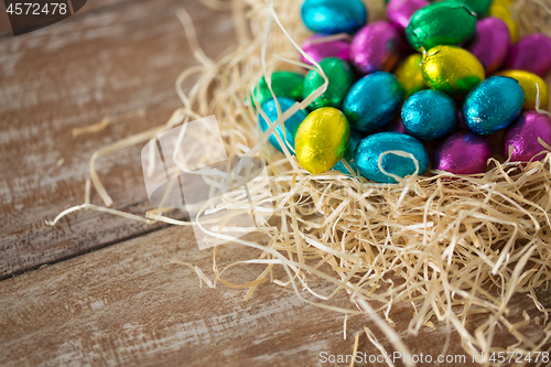 Image of chocolate eggs in foil wrappers in straw nest