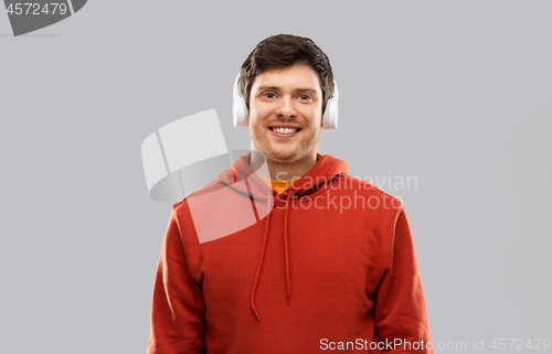 Image of happy young man in headphones and red hoodie