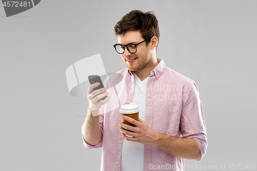 Image of man in glasses with smartphone drinking coffee