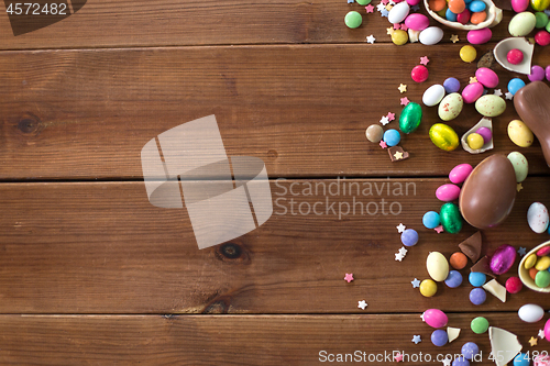 Image of chocolate eggs and candy drops on wooden table