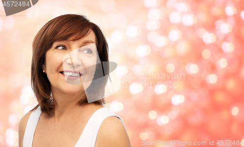 Image of portrait of smiling senior woman over white