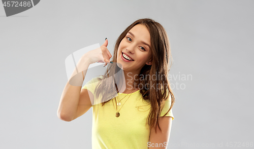 Image of young woman or teenage girl showing call gesture