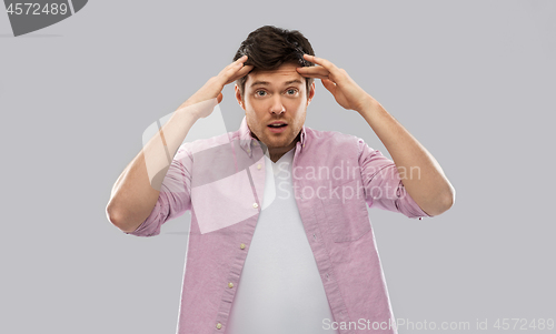 Image of man touching his head