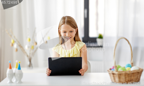 Image of happy girl with tablet pc and easter eggs at home
