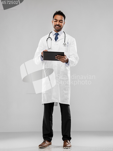 Image of smiling indian male doctor with tablet computer