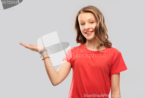 Image of smiling teenage girl holding empty hand