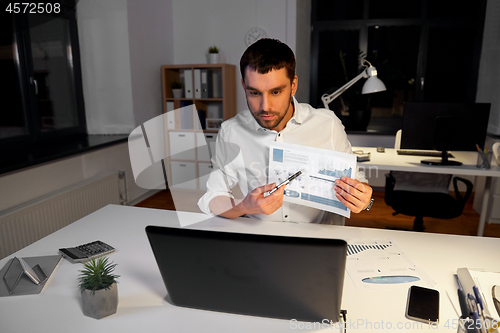 Image of businessman having video chat at night office