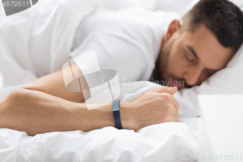 Image of close up of man sleeping with activity tracker