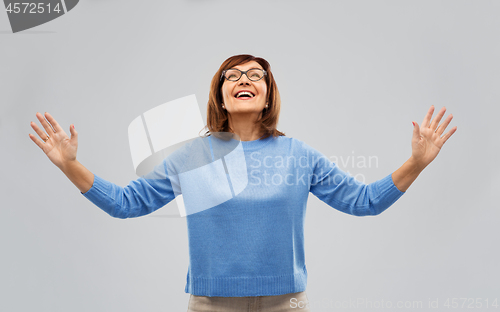 Image of happy senior woman looking up thanks god