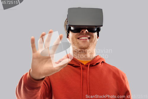 Image of happy man in virtual reality headset or vr glasses