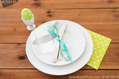 Image of easter egg in cup holder, plates and cutlery