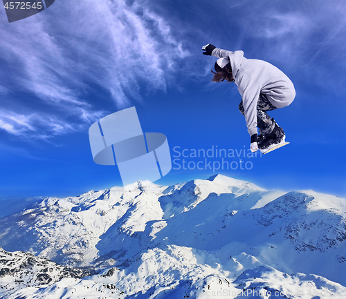 Image of Skier Snowboarder jumping through air with sky in background