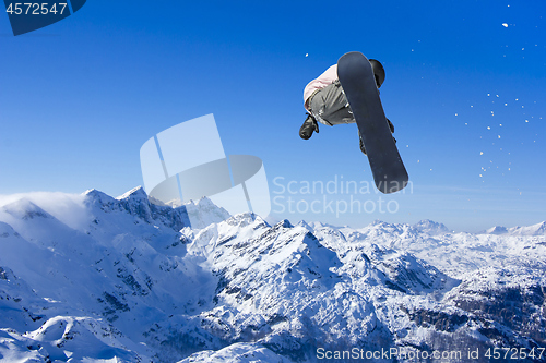 Image of Skier Snowboarder jumping through air with sky in background