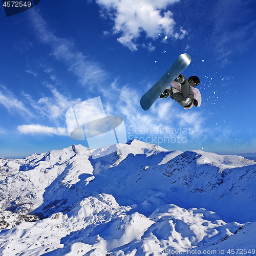 Image of Skier Snowboarder jumping through air with sky in background