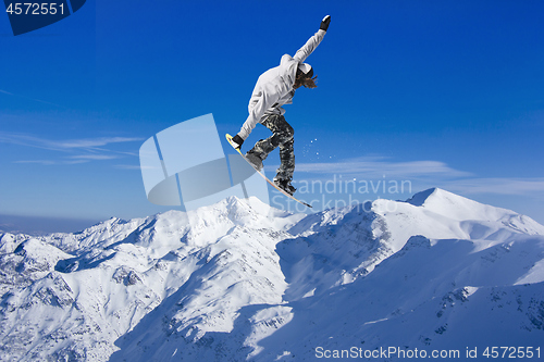 Image of Skier Snowboarder jumping through air with sky in background