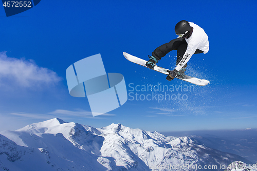 Image of Skier Snowboarder jumping through air with sky in background