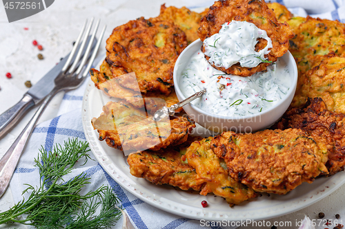 Image of Delicious zucchini fritters with yogurt sauce.