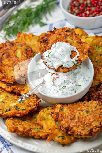 Image of Zucchini fritters with yogurt sauce for breakfast.