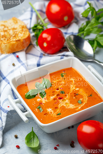 Image of Spicy tomato soup with green basil.
