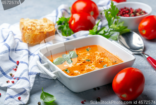 Image of Tomato soup with green basil.