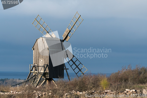Image of Sunlit grey old wooden windmill