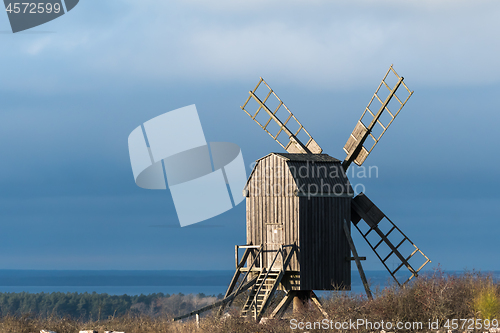 Image of Old wooden windmill in sunlight by fall season