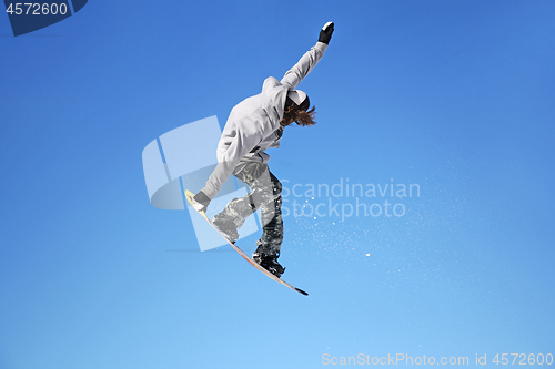 Image of Snowboarder jumping through air with sky in background