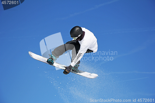 Image of Snowboarder jumping through air with sky in background
