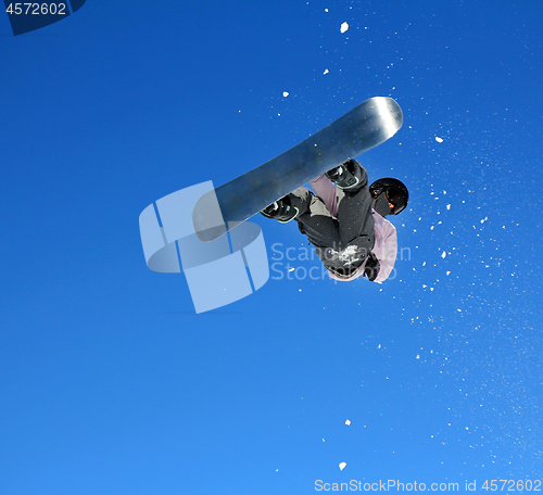 Image of Snowboarder jumping through air with sky in background