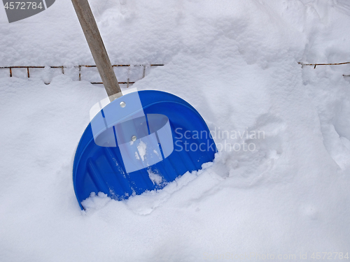 Image of Big blue plastic shovel on fresh snow