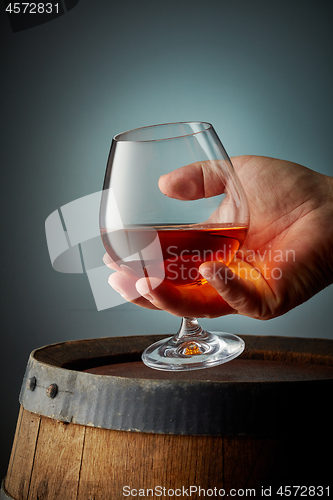 Image of glass of cognac in human hand