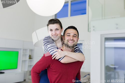 Image of handsome man piggybacking his girlfriend