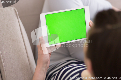 Image of woman on sofa using tablet computer