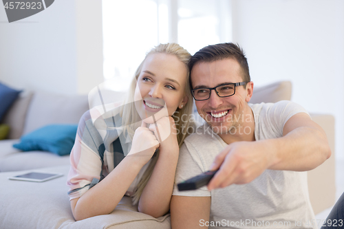 Image of Young couple on the sofa watching television