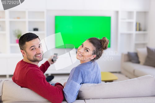 Image of Young couple on the sofa watching television