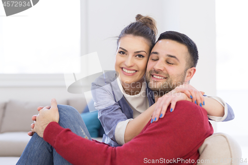 Image of couple hugging and relaxing on sofa