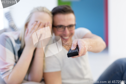 Image of Young couple on the sofa watching television