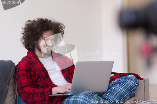 Image of man freelancer in bathrobe working from home