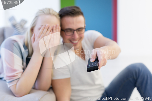 Image of Young couple on the sofa watching television