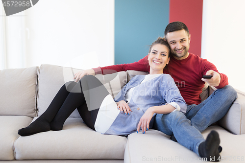 Image of Young couple on the sofa watching television