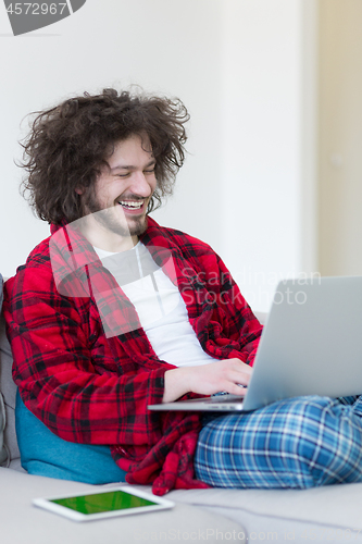 Image of man freelancer in bathrobe working from home