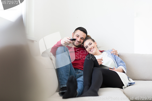 Image of Young couple on the sofa watching television