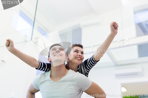 Image of handsome man piggybacking his girlfriend