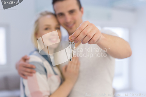 Image of couple showing a keys of their new house