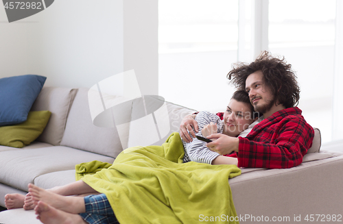 Image of Young couple on the sofa watching television