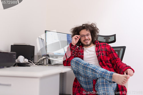 Image of graphic designer in bathrobe working at home