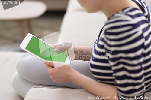 Image of woman on sofa using tablet computer