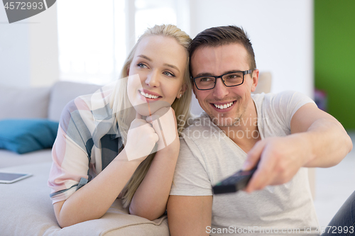 Image of Young couple on the sofa watching television