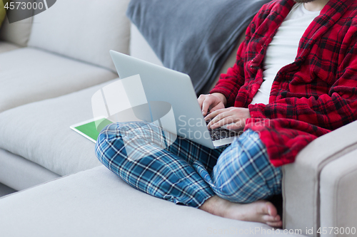 Image of man freelancer in bathrobe working from home