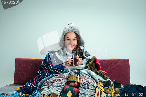 Image of The young woman with Flue Sitting on Sofa at Home. Healthcare Concepts.